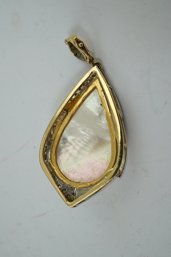 A modern yellow metal, mother of pearl and diamond chip set pear shaped pendant, overall 43mm, together with an Indian? yellow metal pendant, inset with figure. Condition - fair